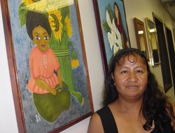 Hermelinda Espinoza, Adult Learner, pictured next to her artwork showcased at the Marion Baysinger Memorial Library